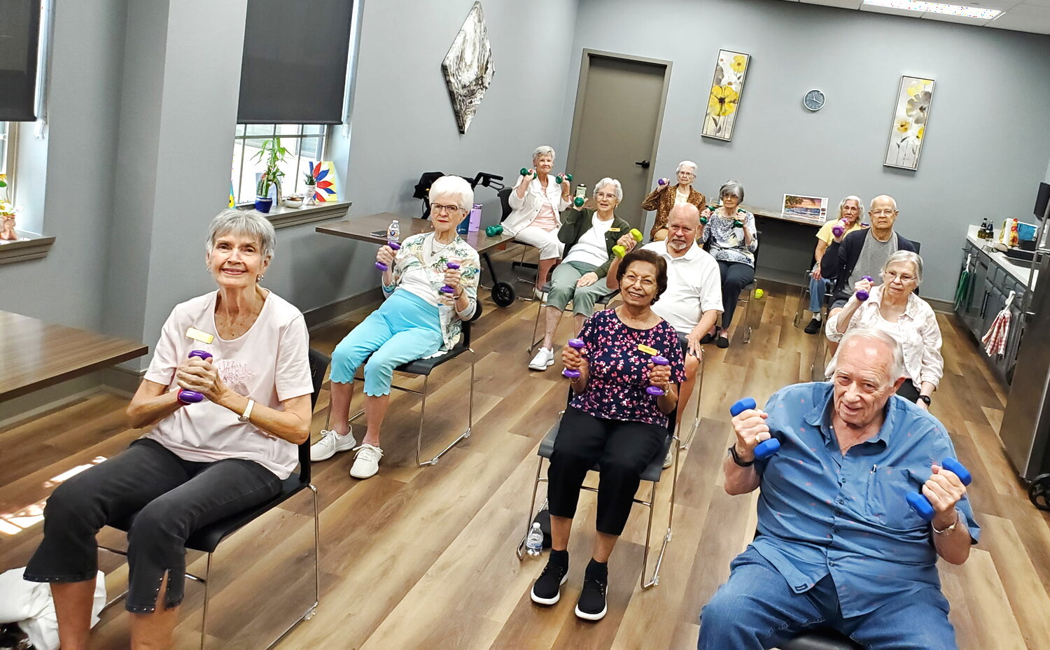Older adults in a Strength and Functional Fitness class holding light hand weights